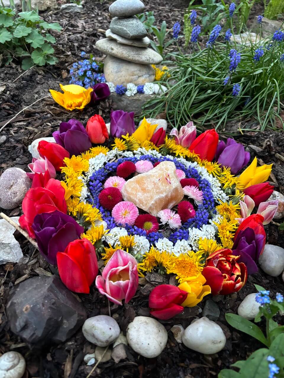 Mandala aus Blüten und Steinen